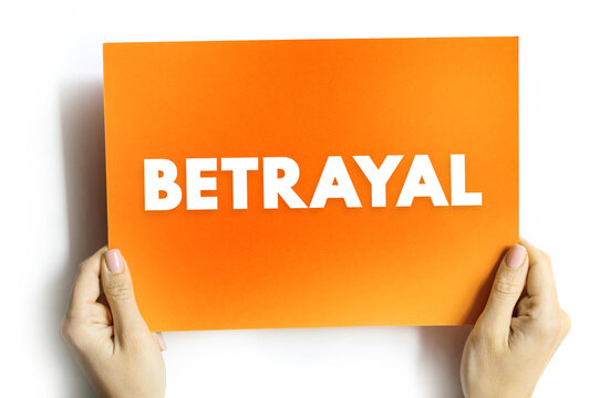 BETRAYAL text on card held by hands, concept of trust, emotion, relationship, and deception