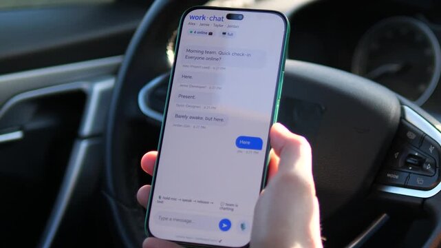 Remote Employee Checking In via Work Chat App in Car. Close-up of a professional using a messaging app for a team check-in while in a vehicle. User types Here on a smartphone. Perfect for videos about