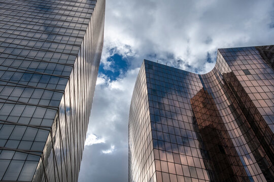 Glass buildings architecture skyscraper office reflections and sky with sharp perspective rising in Paris La Defense financial quarter highrise