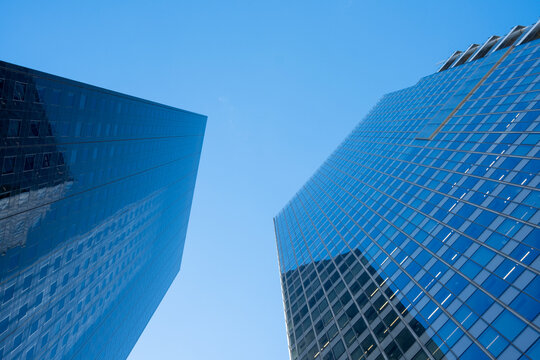 Glass facade architecture skyscraper office with reflections and dramatic perspective looking up in Paris La Defense financial quarter towers