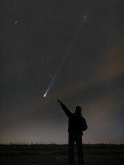 Silhouette of a man pointing at comet © Filip