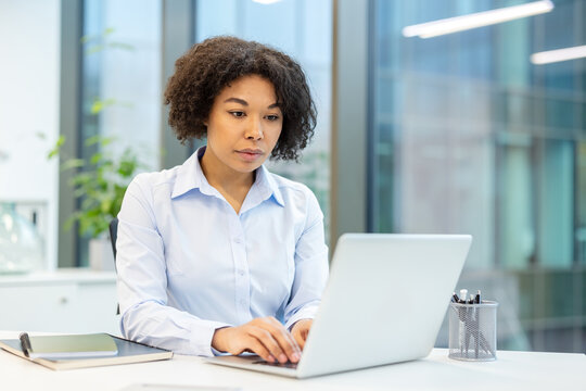 Photo of a serious and focused young businesswoman working in the office on a laptop