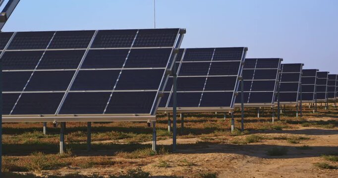 Rows of photovoltaic solar panels at a renewable energy farm in dry open landscape Clean power infrastructure with metal supports blue sky sustainable electricity generation and green technology conce