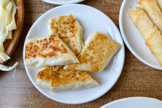 Delicious flatbread served on a white plate next to other dishes during a meal at a local eatery