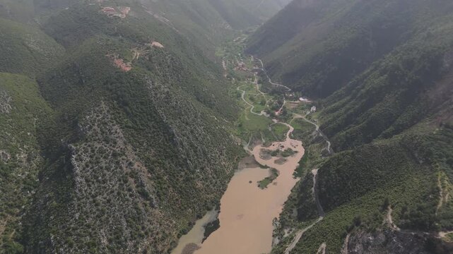 Drone footage of a lake dam in Oyoun El Samak Akkar with calm water, mountains and outdoor scenery