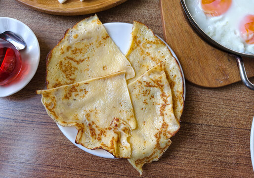 Delicious pancake dish served on a white plate with side dishes in a cozy restaurant setting