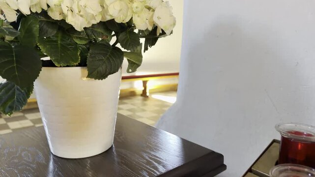 White hydrangea pot beside red votive candles