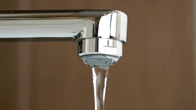 Water under weak pressure flows from a water tap.