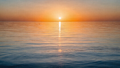 Naklejka premium Sun Over Calm Ocean Horizon at Sunset With Blue and Orange Hues