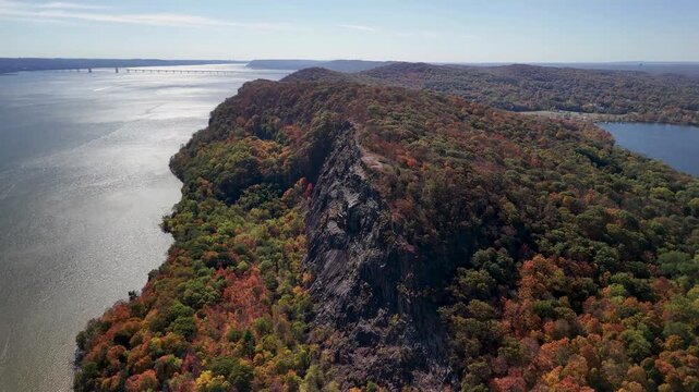 Aerial view of Breakneck Ridge with its craggy rocks meeting the colorful autumn foliage along the Hudson River, Beacon, New York, United States.