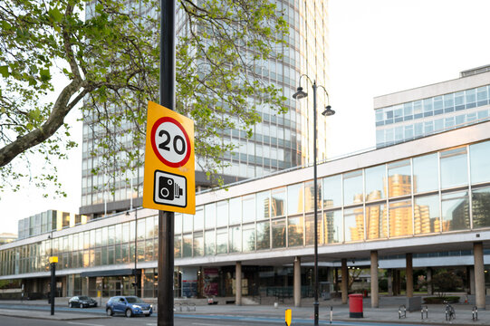 Shallow focus of a typical 20 mph speed enforcement sign seen together with a warning of traffic cameras. Seen on the embankment near the river Thames.