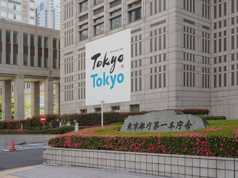 TOKYO, JAPAN - May 2, 2023: Detail of the Tokyo Metropolitan Government Building with a poster on a wall promoting the city.
