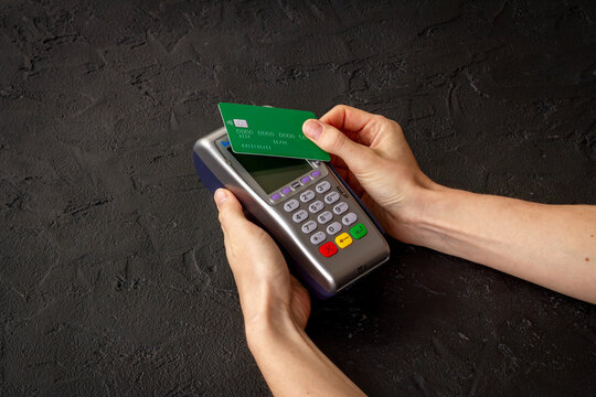 Contactless payment process - hand holding credit card near POS terminal, tap to pay, fintech transaction