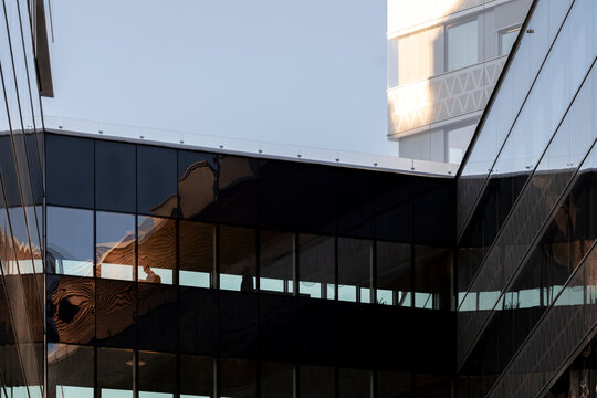 Geometric bridge architecture shows modern glass facade reflection with urban lines and a distant silhouette creating a refined abstract structure