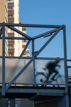 Cyclist motion on a modern steel bridge highlights urban architecture with a soft silhouette and clear structure built for connection and mobility