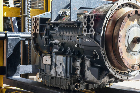 Balikpapan-Indonesia april 27, 2026 A side view of a large black Allison automatic transmission for commercial trucks or buses, secured on a metal lift stand in a workshop environment.
