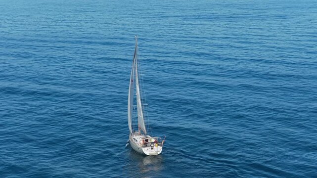 White sailboat sailing in deep blue mediterranean sea near alicante