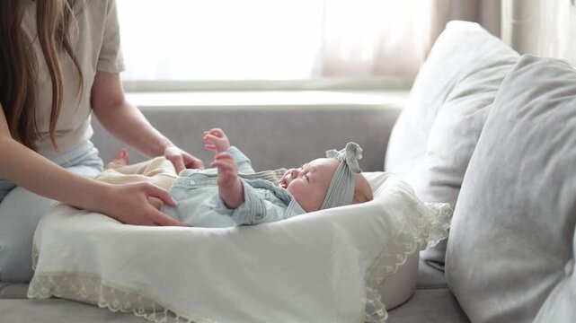 Gentle mother caring for her newborn baby in a cozy bassinet