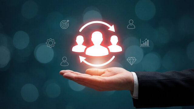 A hand holds a glowing icon of three people in a circular flow with surrounding business symbols.
