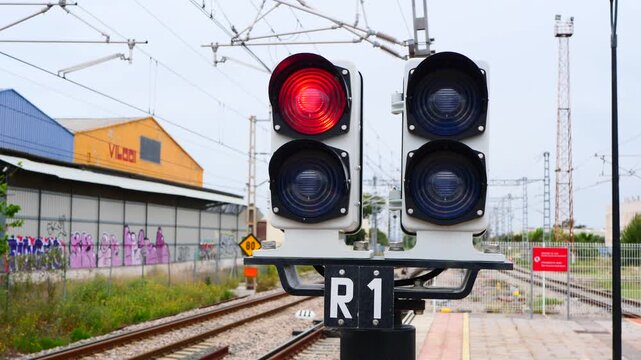Red railway semaphore signal glowing at train station, indicating stop and safety control in transportation system. Ideal for transport concepts, warning visuals, infrastructure themes