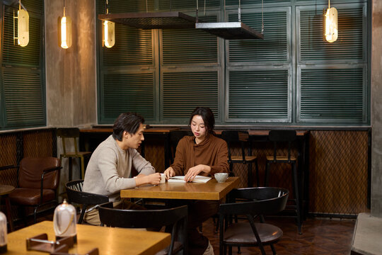 Over cups of fine tea, a couple shares conversation and a good book in a tranquil tea house