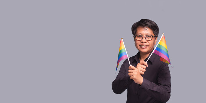Businesswoman holding rainbow flags celebrating Pride Month

