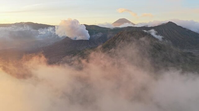 Aerial view revealing smoking volcanoes at sunrise
