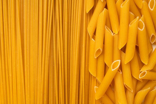 Background of uncooked macaroni of various shapes. Italian pasta close-up. Fusilli, penne pasta, spaghetti. Healthy food made from wheat flour