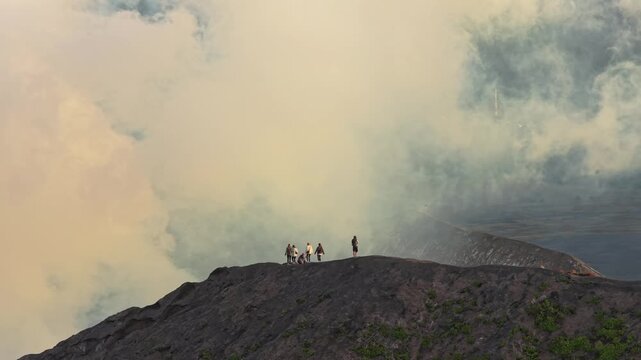 Tourists standing on the bromo volcano crater rim in indonesia