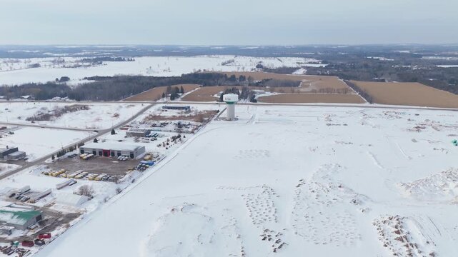 Aerial Flyover Of A Snow Covered Landscape During Winter In Erin Water Tower In Ontario, Canada.