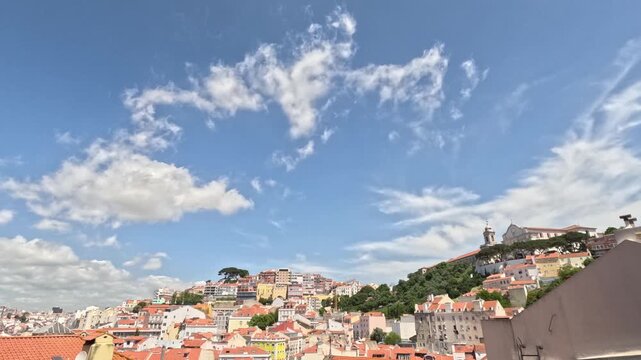 Lisbon old town viewpoint over rooftops. Skyline cityscape time lapse facing Alfama, Graca, Anjos and Martim Moniz neighbourhoods. Historic centre terracotta roofs. Portugal time-lapse, neutral