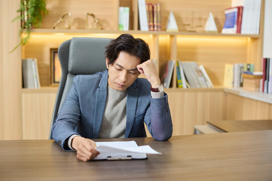 A businessman examines documents at his workstation