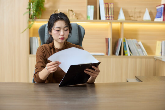 A businesswoman examines documents at her desk