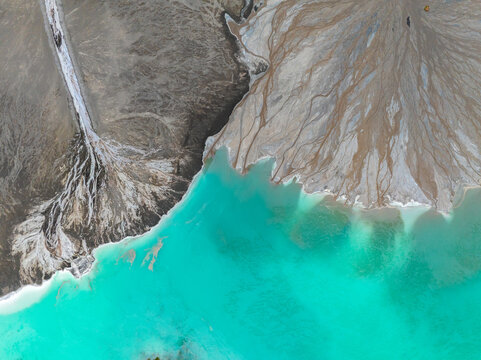 Aerial view of striking turquoise waters meeting desolate, eroded land, revealing a stark contrast of vibrant liquid and parched earth, Tuzla, Bosnia and Herzegovina.