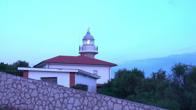 Active lighthouse in Suances at sunrise with rotating beacon light and morning sky in Cantabria Spain