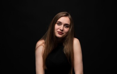 Naklejka premium Young woman smiling with confident expression on dark background representing positivity and individuality