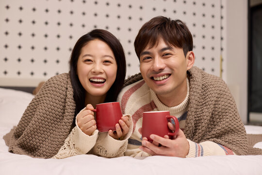 A lovely young couple stays cozy in bed