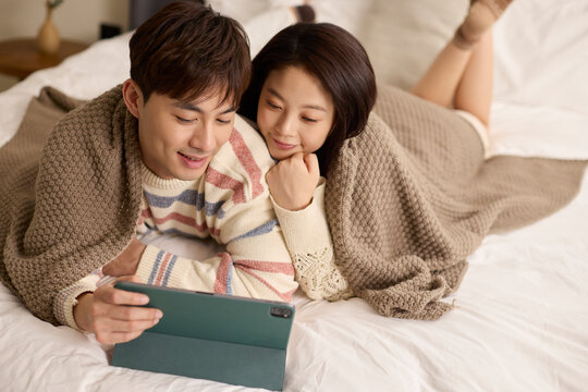 A lovely young couple stays cozy in bed