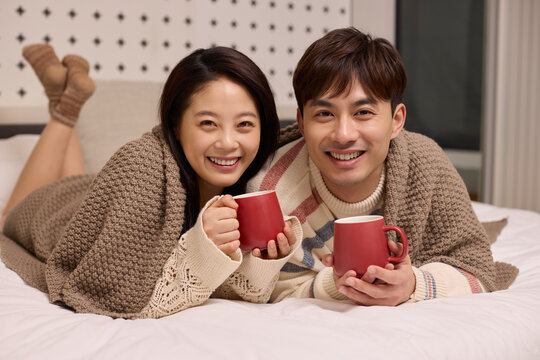 A lovely young couple stays cozy in bed