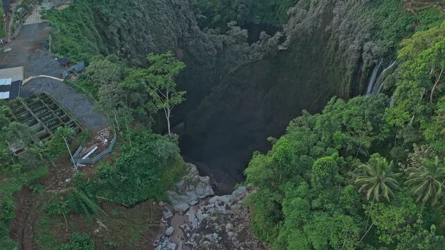 Aerial drone flying towards tumpak sewu waterfall in indonesia