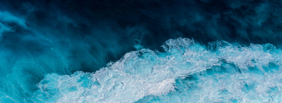 Banner Blue ocean Turquoise sea water white foam wave pattern splashing deep blue sea. Banner Tropical sea beach Seascape dark background splash on rock. Summer Ocean Surface wave with copy space