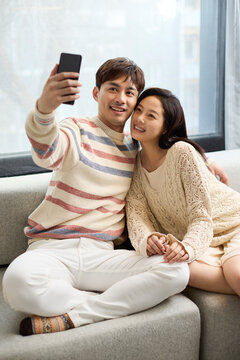 A young couple snuggling closely on the sofa