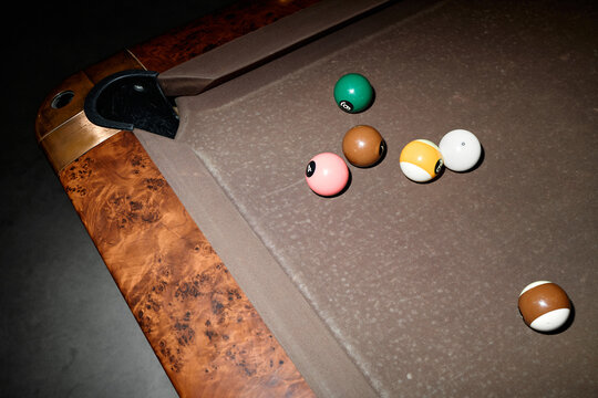 Close up of billiard balls clustering near corner pocket on pool table, suggesting competition and strategy. Useful for sports marketing, gaming promotion, leisure branding
