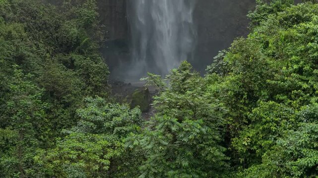 Powerful kabut pelangi waterfall in indonesian jungle