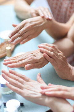 Senior female friends try out new cosmetics and beauty products