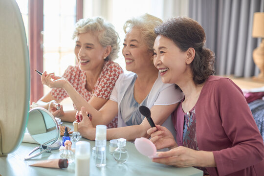 Senior female friends try out new cosmetics and beauty products