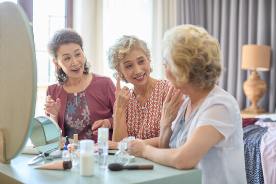 Senior female friends try out new cosmetics and beauty products