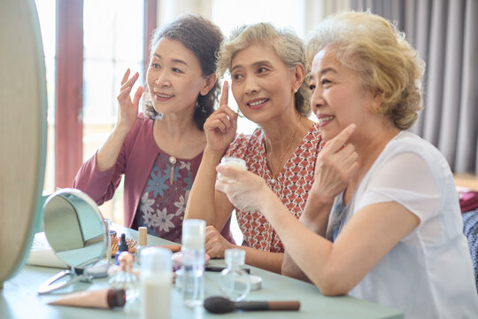 Senior female friends try out new cosmetics and beauty products