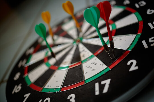 Close up of darts hitting bullseye area on dartboard, representing goal achievement, precision, strategy, competition. Ideal for business targets, performance metrics, success campaigns
