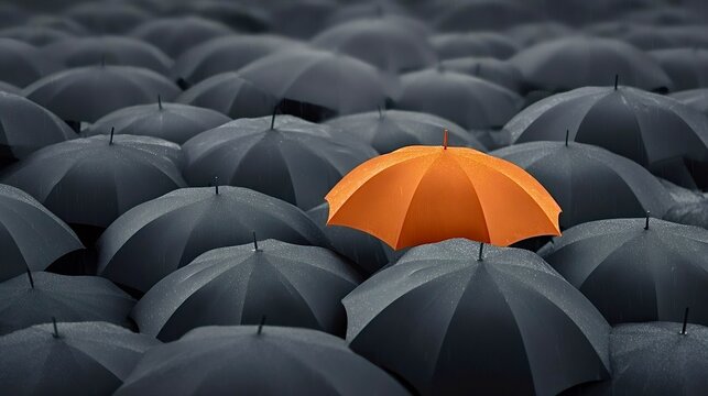 Orange umbrella standing out from the gray crowd